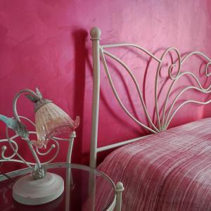 a bedroom with a bed with a pink wall at MAISON PLATONE in Alessandria