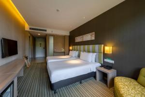 een hotelkamer met een groot bed en een bank bij Wanda YUE Changbaishan in Baishan