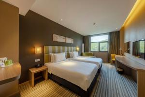 白山市にあるWanda YUE Changbaishanの大きなベッドとデスクが備わるホテルルームです。