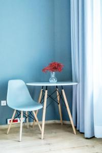 a table with a vase of flowers and a chair at Moon Hostel Warszawa in Warsaw