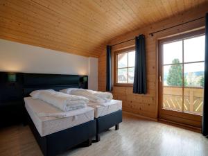 - une chambre avec 2 lits et une grande fenêtre dans l'établissement Holiday home in ski area in Mauterndorf with sauna, à Begöriach