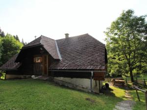 ein altes Haus mit einem braunen Dach auf einem Hof in der Unterkunft Chalet in Prebl Carinthia with sauna near ski area in Prebl