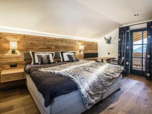 1 dormitorio con 1 cama grande y pared de madera en Premium chalet in Wagrain with 2 saunas and pool, en Wagrain