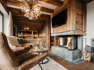 salon z kominkiem i żyrandolem w obiekcie Chalet in Wagrain near Ski Lift w mieście Wagrain +26 zdjęć
