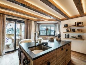 a kitchen with a sink and a large window at Premium chalet in Wagrain with 2 saunas and pool in Wagrain