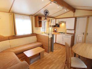 a living room and kitchen with a couch and a table at Mobile home near Lake Klopeiner See in Sankt Kanzian