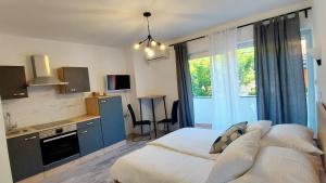a bedroom with a bed and a kitchen with a window at Guest House Galeb in Supetarska Draga