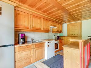 a kitchen with wooden cabinets and white appliances at Apartment on the mountainside in Silbertal in Silbertal