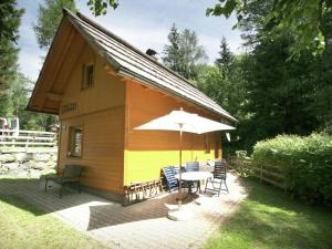 バート・クラインキルヒハイムにあるHoliday home in Bad Kleinkirchheim near ski areaの小屋(テーブル、傘付)