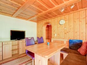 una sala da pranzo con tavolo in legno e sedie viola di Apartment in Silbertal near Ski Lift a Silbertal