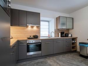 una cocina con electrodomésticos de acero inoxidable y armarios de madera en Maisonette in St Michael Lungau near Katschberg en Sankt Michael im Lungau