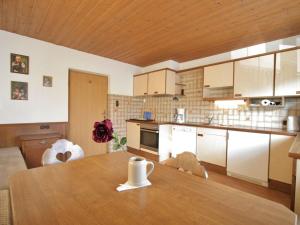 eine Küche mit einem Holztisch mit einer Tasse drauf in der Unterkunft Beautiful Holiday Home near Ski Area in Ellmau in Ellmau