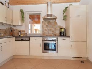 uma cozinha com armários brancos e um fogão em Chalet in Koetschach Mauthen near ski slope em Kötschach