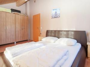 een slaapkamer met een groot bed met witte lakens bij Chalet in Koetschach Mauthen near ski slope in Kötschach
