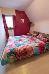een slaapkamer met een groot bed en een kleurrijk dekbed bij Gezellige woning met 3 slaapkamers en gratis parking in Deinze