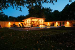 a gazebo with lights in a yard at night at Vila Casa din gradina in Voivodeni