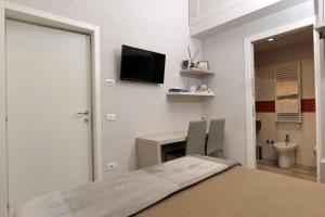 ein Schlafzimmer mit Bett und Schreibtisch sowie ein Badezimmer in der Unterkunft Relais Marlene in Avezzano