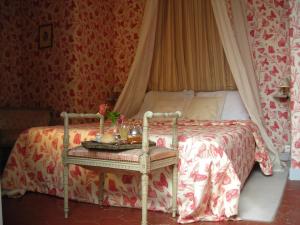 a bedroom with a canopy bed with a table at La Marronniere in Cheffes-sur-Sarthe