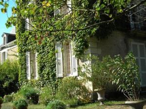 a house with ivy growing on the side of it at La Marronniere in Cheffes-sur-Sarthe