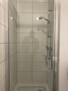 La salle de bains est pourvue d'une douche avec une porte en verre. dans l'établissement NG SuiteHome - Lille I Roubaix Rémy Cogghe - Studio - Netflix - Wifi, à Roubaix