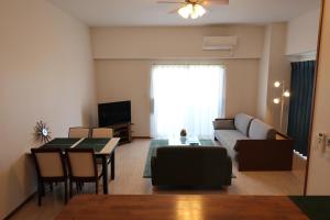 a living room with a couch and a table at AP YOURS　Hotel４０１ in Okinawa City