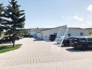 un estacionamiento con autos estacionados al lado de un edificio en Gästezimmer Ödenburgerstraße, en Pöttsching