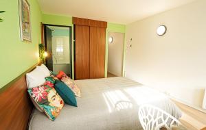 Un dormitorio con una cama grande con almohadas de colores. en UXCO Grenad'inn, en Burdeos