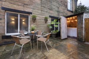 een patio met een tafel en stoelen en een gebouw bij Rosie's Escape with Hot Tub in Barrowford