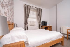 a bedroom with a white bed and a window at Lauriston Hotel in Weston-super-Mare