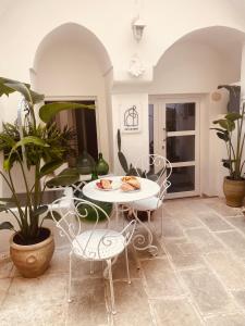 a table and chairs in a room with plants at Corte San Giorgio in Matino