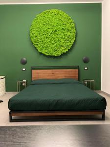 ein Schlafzimmer mit einem Bett mit einer grünen Wand in der Unterkunft B&B SOUL Messina in Messina