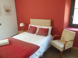 Un dormitorio con una cama blanca y una silla. en Casa Rural Laguna Negra, en Vinuesa