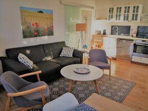 a living room with a couch and a table and chairs at Wohnung Luv - Alte Schule in Glowe