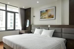 a bedroom with a large bed with white sheets at Van Nam Hotel in Ha Long
