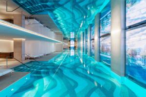 a swimming pool in a building with blue ceilings at Cheval Blanc Paris & Dior Spa Cheval Blanc Paris in Paris