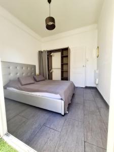 sypialnia z dużym łóżkiem w białym pokoju w obiekcie Appart hôtel plage des capucins w mieście La Ciotat