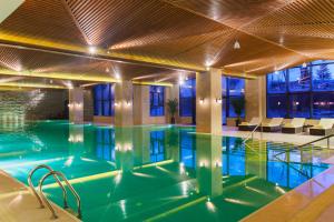 a swimming pool in a building with a ceiling at Wanda Jin Resort Changbaishan in Baishan