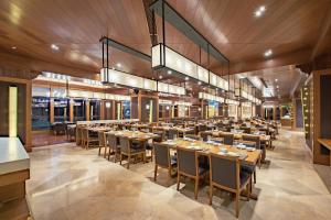 uma grande sala de jantar com mesas e cadeiras em Wanda Jin Resort Changbaishan em Baishan