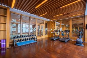 a gym with several treadmills and elliptical machines at Wanda Jin Resort Changbaishan in Baishan