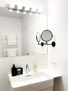 uma casa de banho branca com um lavatório e um espelho em PAM Apartments em Kaprun