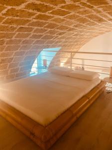 a bed in a room with a brick wall at Corte San Giorgio in Matino