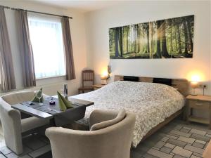 Schlafzimmer mit einem Bett, einem Tisch und Stühlen in der Unterkunft Hotel Schröder in Losheimergraben
