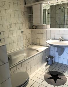 un bagno con vasca, WC e lavandino di Strandhotel S33-213 a Heiligenhafen