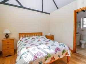 a bedroom with a bed and a bathroom at White Hart Stables in Battle