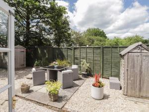 a garden with chairs and a sink and a fence at White Hart Stables in Battle