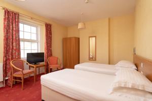 a hotel room with two beds and a desk with a computer at Lauriston Hotel in Weston-super-Mare
