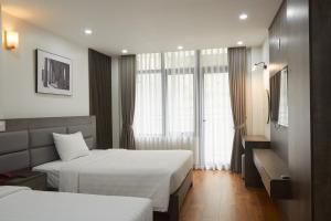 Łóżko lub łóżka w pokoju w obiekcie Van Nam Hotel