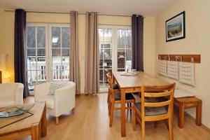 - une cuisine et une salle à manger avec une table et des chaises dans l'établissement Ferienhaus Am Fulgenbach, à Klein Bollhagen