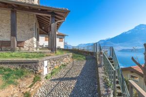 a stone walkway next to a building with a view of a lake at Apartment Alex 2 in Domaso in Domaso