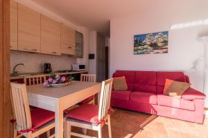 sala de estar con mesa y sofá rojo en Apartment Alex 2 - Domaso, en Domaso